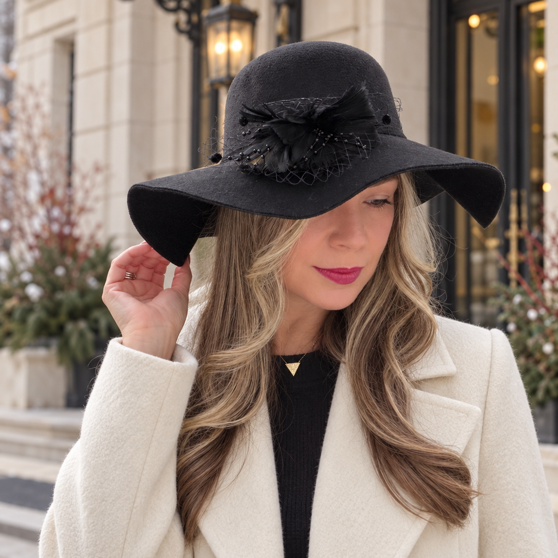 Woman wearing the Lore black wool felt floppy hat with an ivory coat outdoors — Fall & Winter Hats