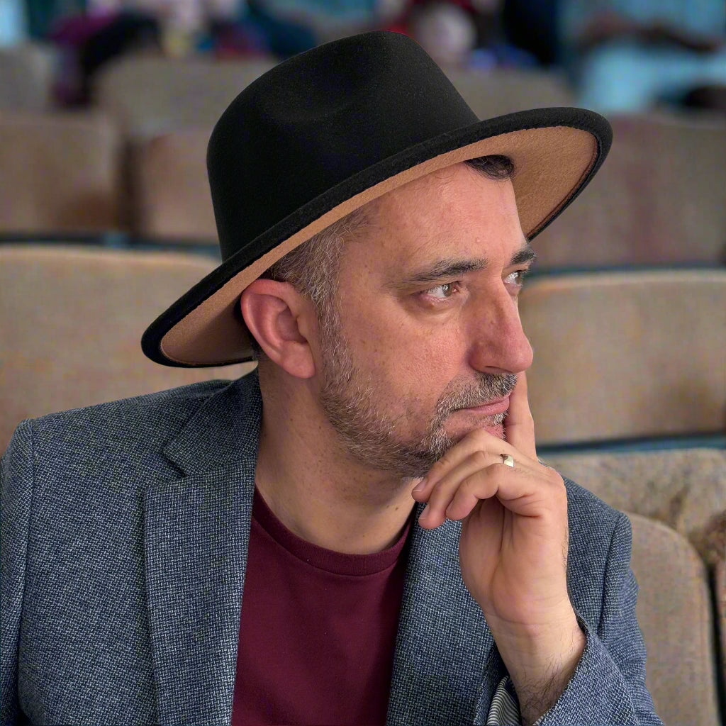 Man wearing Zair black fedora with a contrasting tan brim underside.