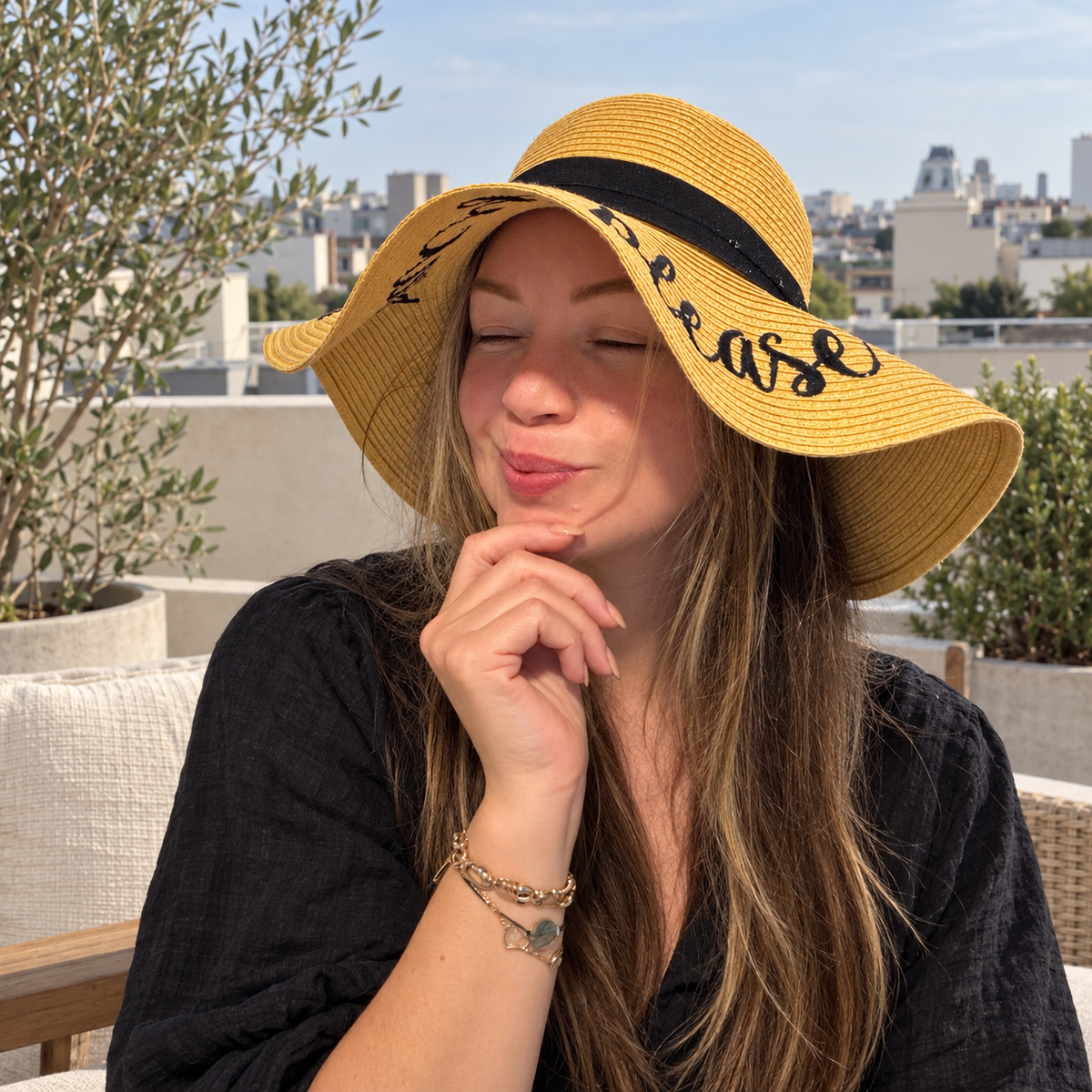Woman wearing Elizabeth embroidered floppy brim sun hat on a rooftop terrace