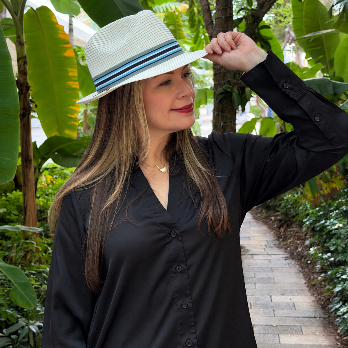 Woman wearing Lira white fedora with a blue striped band outdoors.