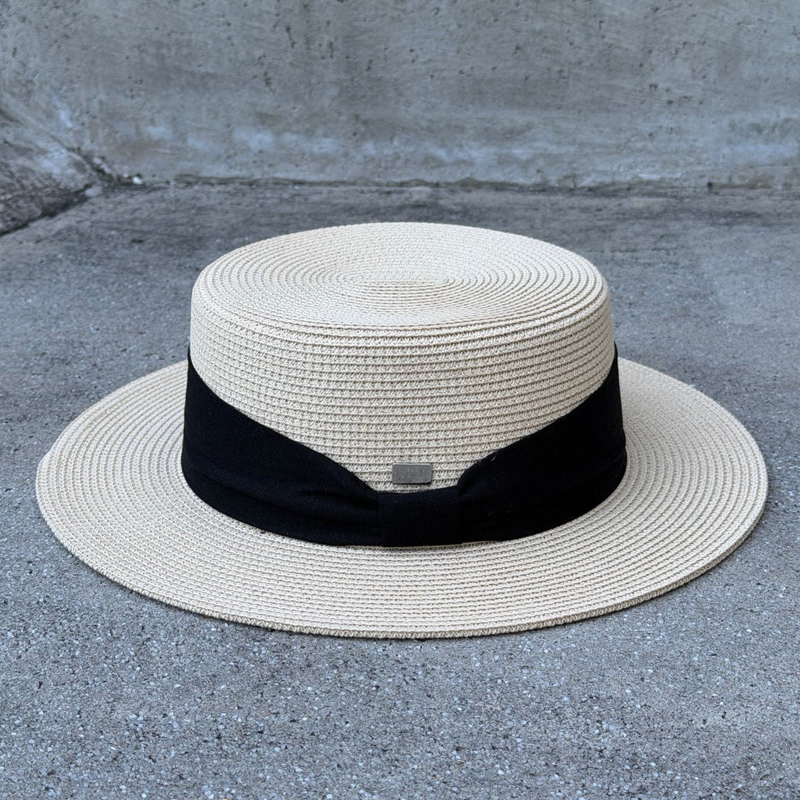 Lola Beige boater hat, rear view with black ribbon and small brand pin