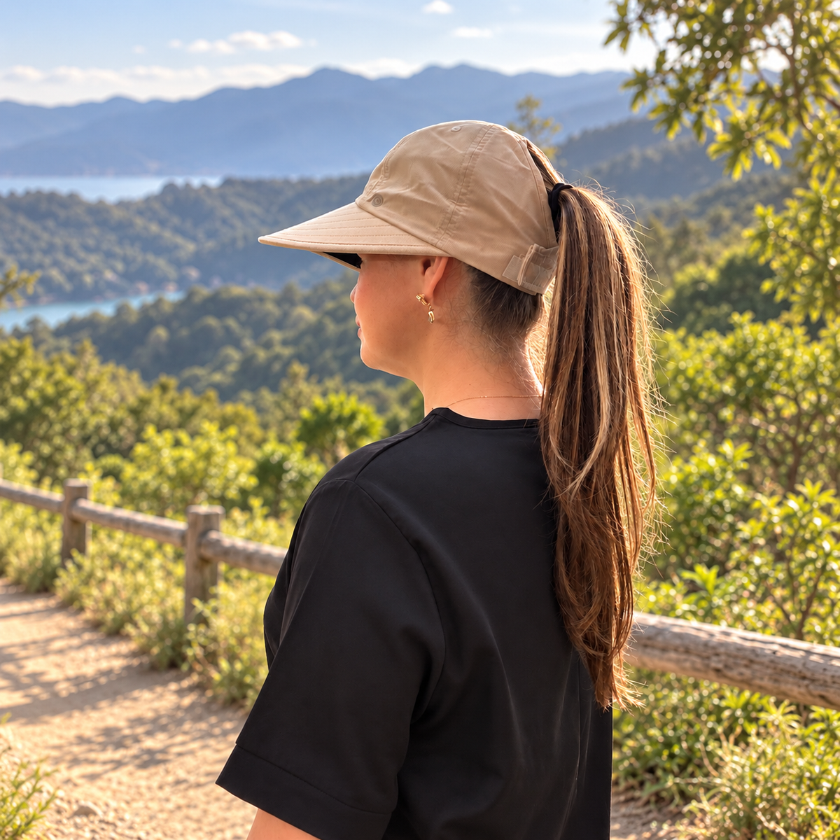 Rear side view of the beige Pia visor hat showing the ponytail opening and adjustable back closure.
