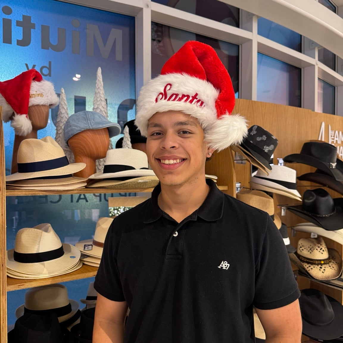Man in a black shirt wearing a red embroidered Santa hat
