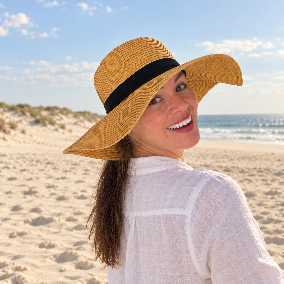 Woman wearing Susana natural floppy sun hat with ponytail at the beach