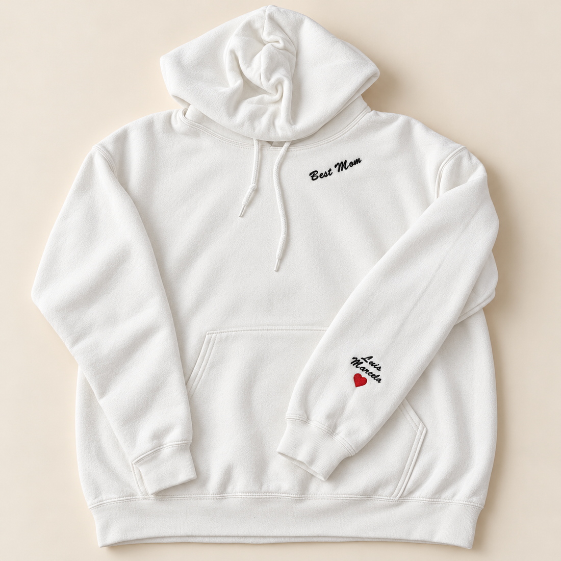 White hoodie with Best Mom chest embroidery and Luis and Marcela names with a red heart on the sleeve
